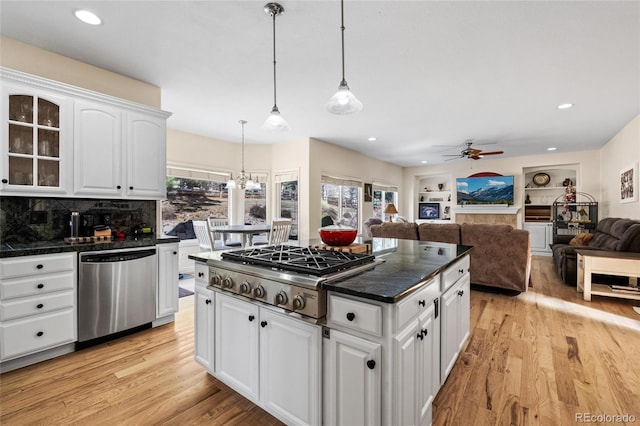 kitchen featuring white cabinetry, dark countertops, light wood-style flooring, and stainless steel appliances