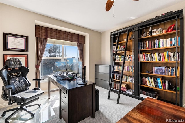 home office featuring baseboards, light carpet, and ceiling fan