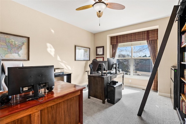 carpeted home office featuring a ceiling fan and baseboards