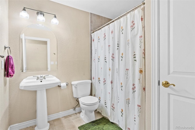 bathroom with tile patterned floors, toilet, a shower with shower curtain, and baseboards