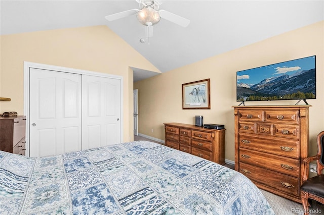 carpeted bedroom with a closet, ceiling fan, and vaulted ceiling