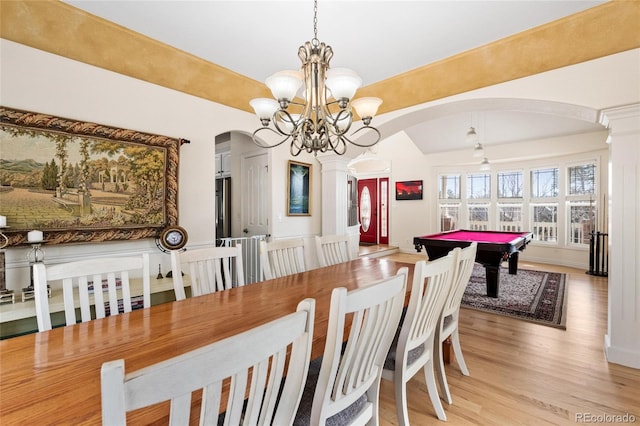 dining space featuring pool table, decorative columns, light wood-style floors, and arched walkways