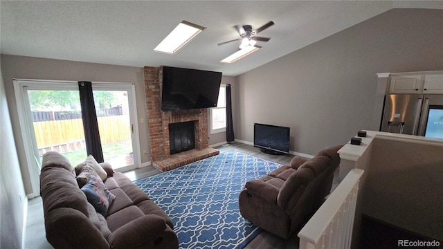 4543 Cathay St, Denver, CO 80249 - living area featuring lofted ceiling, ceiling fan, wood finished floors, a fireplace, and a skylight