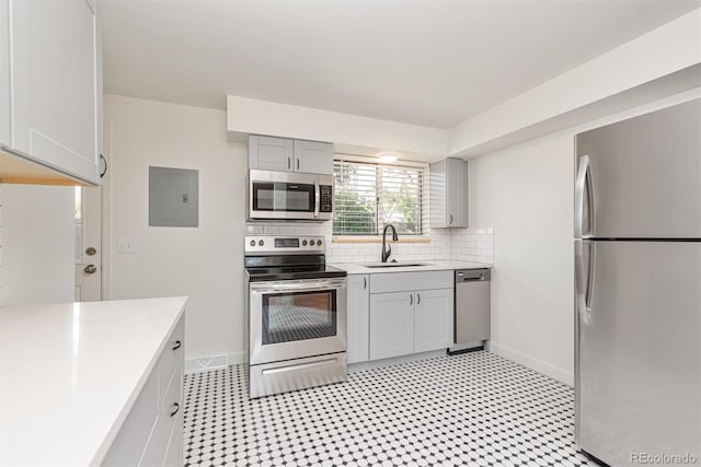 1331 Xanadu St, Aurora, CO 80011 - kitchen with stainless steel appliances, gray cabinetry, light countertops, tasteful backsplash, and electric panel