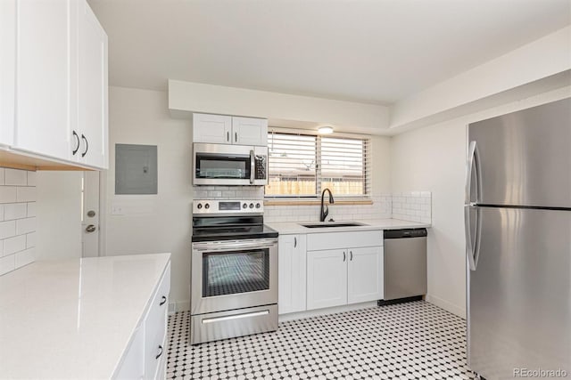 1331 Xanadu St, Aurora, CO 80011 - kitchen with stainless steel appliances, electric panel, white cabinets, and backsplash