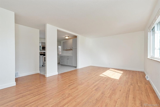1331 Xanadu St, Aurora, CO 80011 - unfurnished living room featuring light wood-type flooring