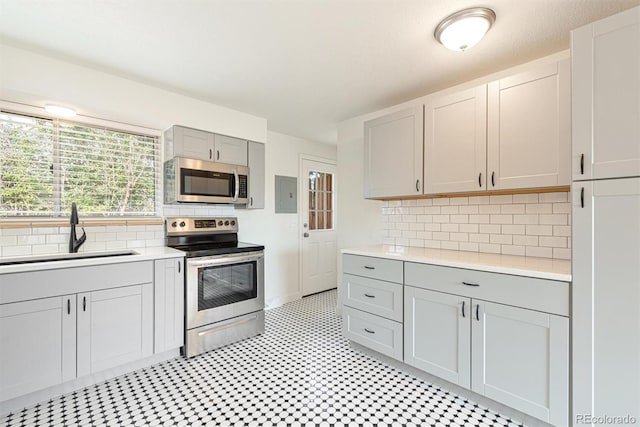 1331 Xanadu St, Aurora, CO 80011 - kitchen featuring stainless steel appliances, gray cabinetry, light countertops, and backsplash