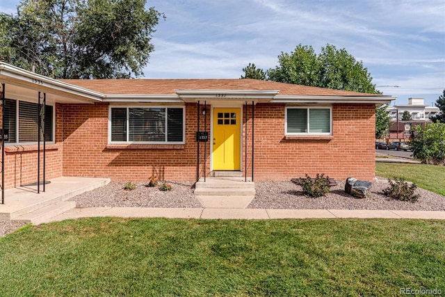 1331 Xanadu St, Aurora, CO 80011 - ranch-style house with a front lawn, brick siding, and a shingled roof