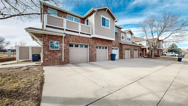 view of side of property with a balcony, a garage, and central air condition unit