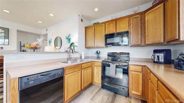 kitchen with light hardwood / wood-style floors, sink, kitchen peninsula, and black appliances