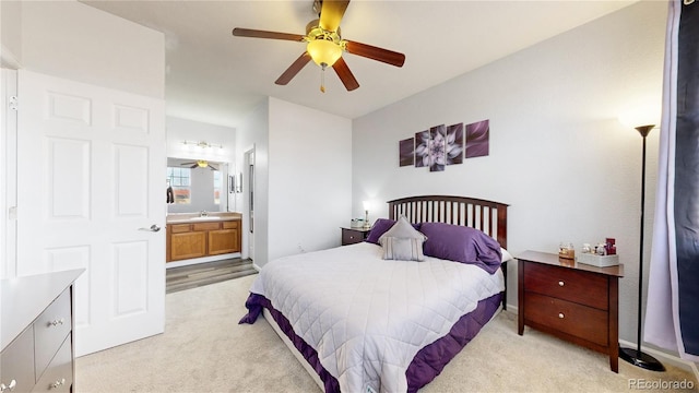 carpeted bedroom with sink, ensuite bath, and ceiling fan