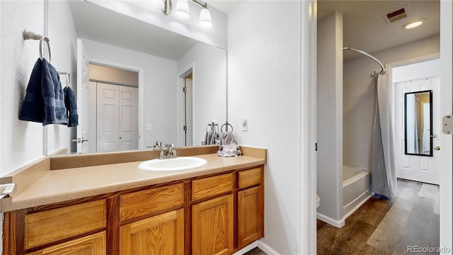 bathroom with vanity, hardwood / wood-style flooring, and shower / tub combo with curtain