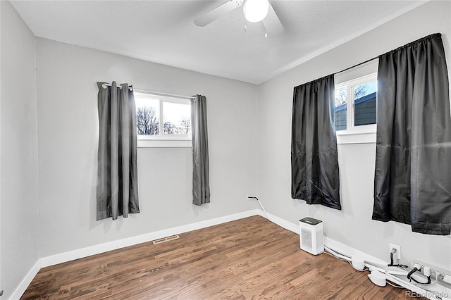 empty room with hardwood / wood-style floors and ceiling fan