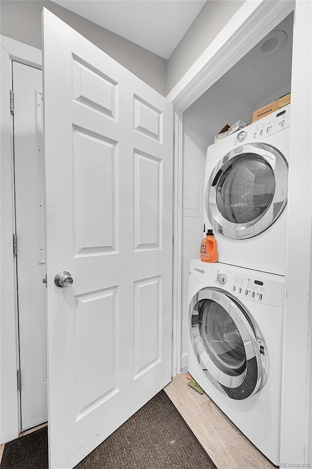 clothes washing area featuring stacked washer / drying machine