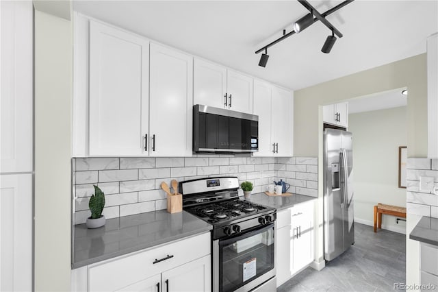 kitchen featuring tasteful backsplash, appliances with stainless steel finishes, track lighting, and white cabinets