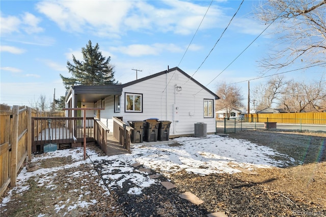 snow covered house featuring central AC