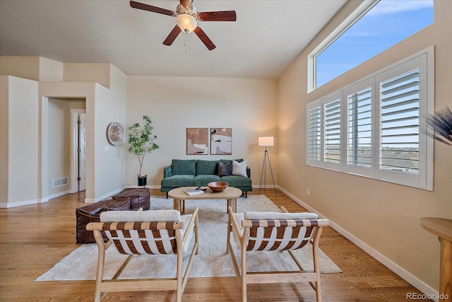 living room with ceiling fan, a healthy amount of sunlight, and light wood-type flooring