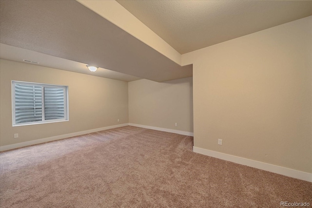 carpeted empty room with a textured ceiling