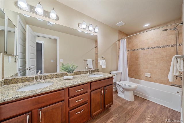 full bathroom featuring vanity, toilet, hardwood / wood-style floors, and shower / bath combo