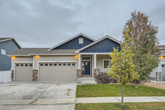 craftsman inspired home featuring a garage and a front lawn