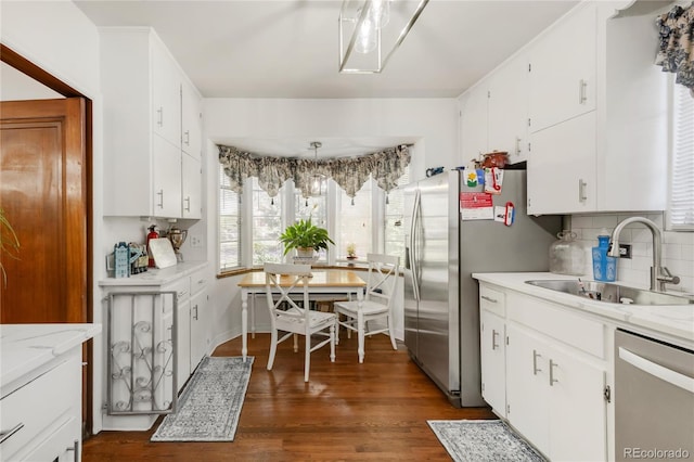 1475 S Monaco St Parkway, Denver, CO 80224 - kitchen with stainless steel appliances, decorative backsplash, dark wood-style flooring, and white cabinets