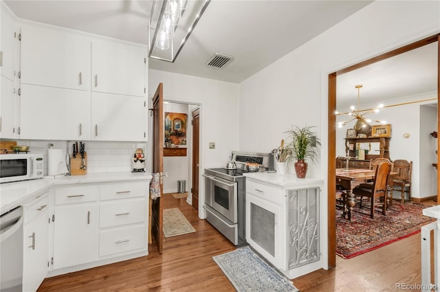 1475 S Monaco St Parkway, Denver, CO 80224 - kitchen with stainless steel appliances, light wood-style floors, decorative backsplash, light countertops, and ornamental molding