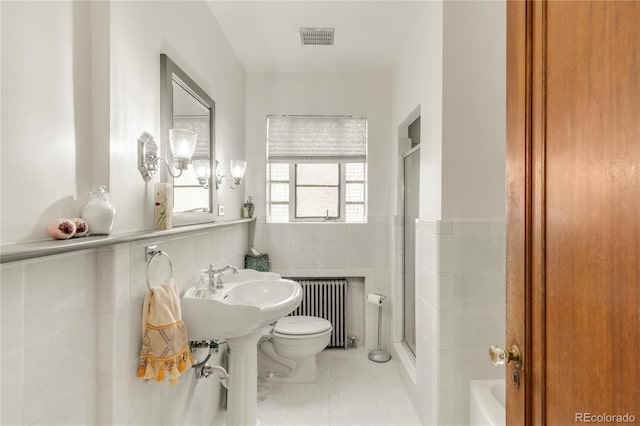 1475 S Monaco St Parkway, Denver, CO 80224 - bathroom with radiator heating unit, tile walls, an enclosed shower, a tub, and wainscoting