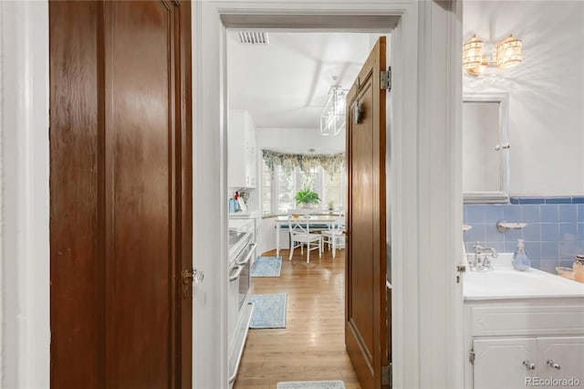 1475 S Monaco St Parkway, Denver, CO 80224 - hall featuring light wood-style flooring and a wainscoted wall