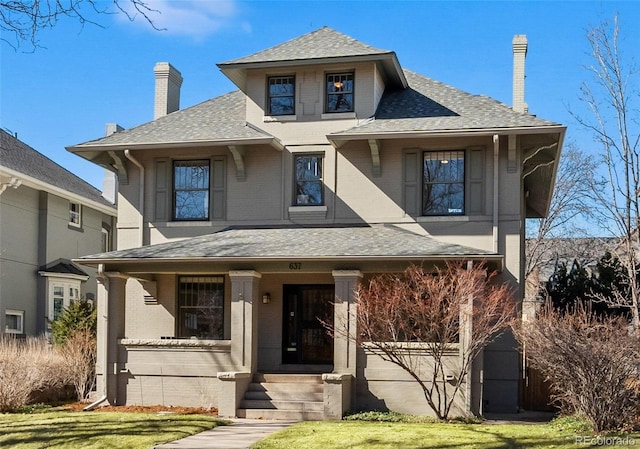 view of front of home with a shingled roof, a chimney, a porch, and a front yard