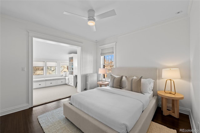 bedroom with baseboards, radiator heating unit, ornamental molding, and wood finished floors
