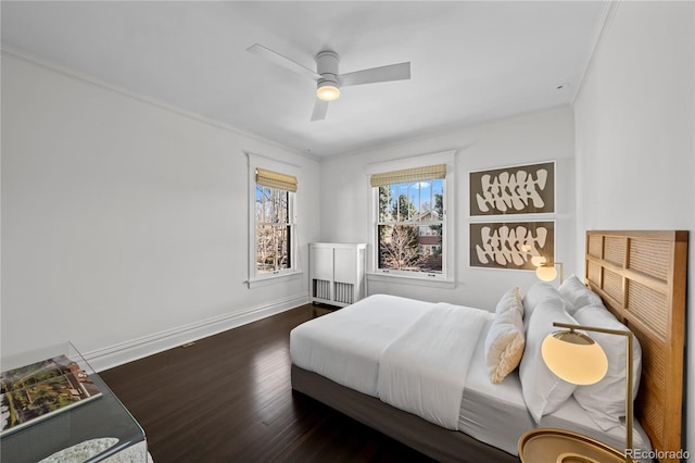 bedroom featuring a ceiling fan, baseboards, wood finished floors, and ornamental molding
