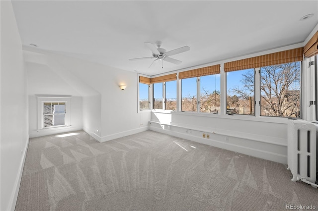 unfurnished sunroom featuring ceiling fan and radiator