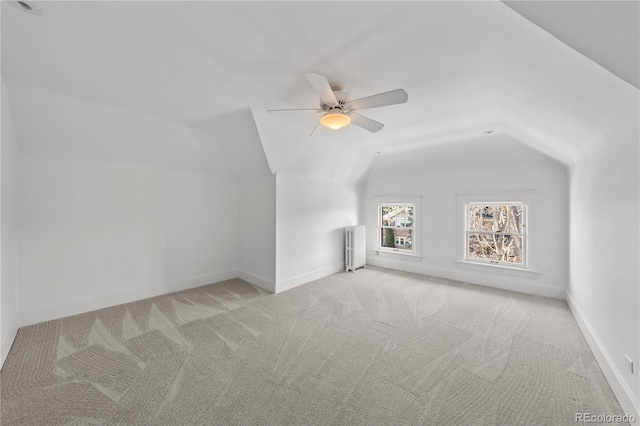 additional living space featuring lofted ceiling, radiator heating unit, carpet flooring, ceiling fan, and baseboards