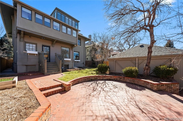 rear view of house with a patio area and fence