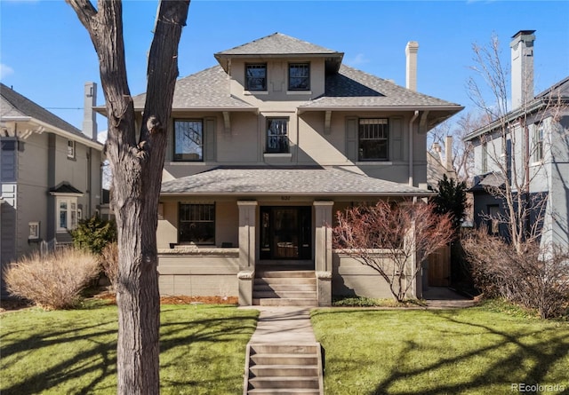 american foursquare style home with a front lawn, a porch, and a shingled roof