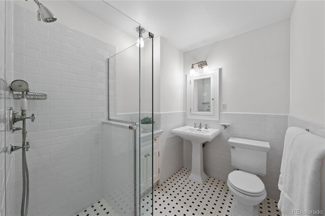 637 N Franklin St, Denver, CO 80218 - full bathroom with a stall shower, a wainscoted wall, toilet, tile walls, and a sink