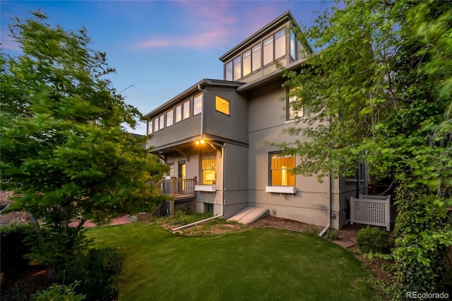 637 N Franklin St, Denver, CO 80218 - back of house at dusk with a lawn and stucco siding