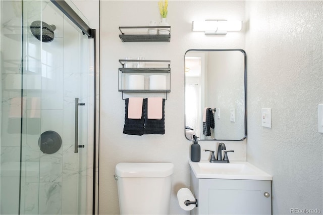 bathroom featuring vanity, an enclosed shower, and toilet