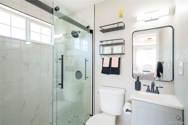 bathroom featuring vanity, toilet, and a shower with shower door