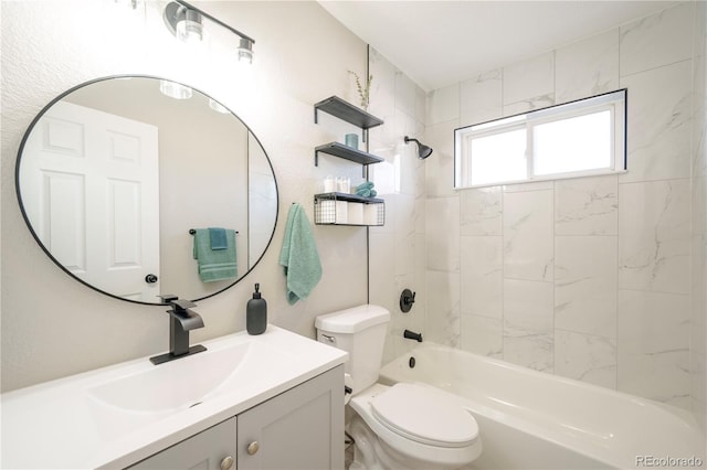 full bathroom featuring vanity, tiled shower / bath combo, and toilet