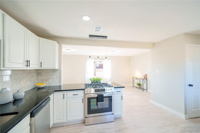 kitchen featuring stainless steel appliances, visible vents, decorative backsplash, white cabinetry, and a peninsula