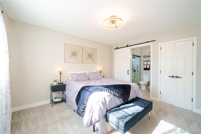 bedroom with carpet, a closet, baseboards, and a barn door