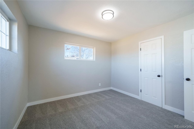 unfurnished bedroom featuring carpet floors and baseboards