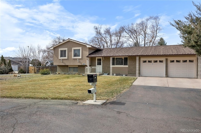 split level home featuring a front lawn, an attached garage, brick siding, and driveway