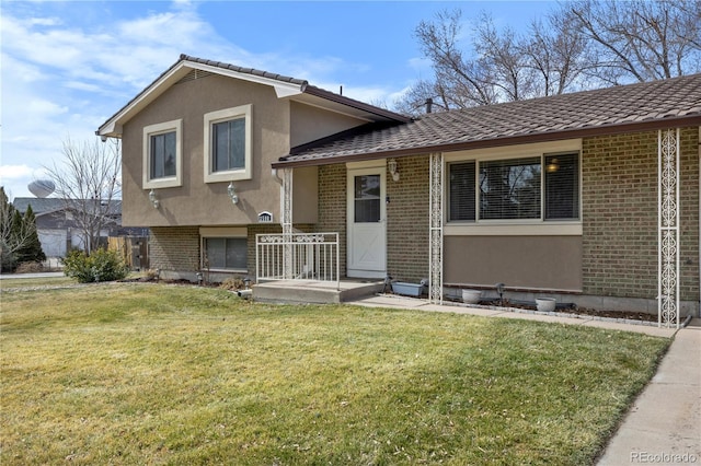 view of front of property with brick siding, stucco siding, and a front lawn