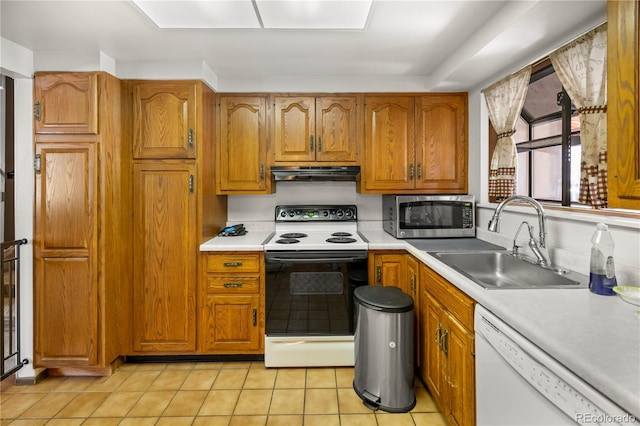 kitchen with stainless steel microwave, under cabinet range hood, white dishwasher, electric range, and a sink