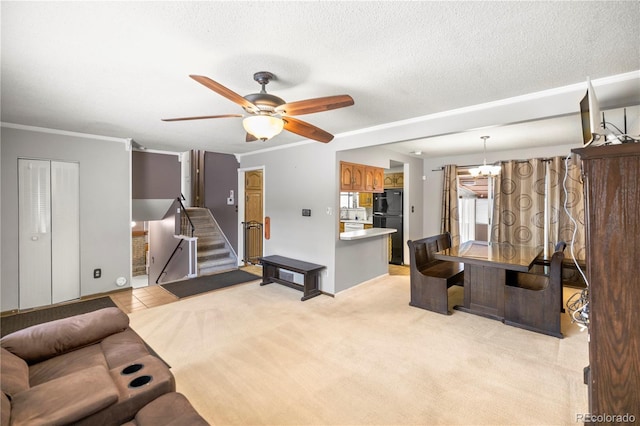 living room featuring ornamental molding, stairs, a textured ceiling, ceiling fan with notable chandelier, and light colored carpet