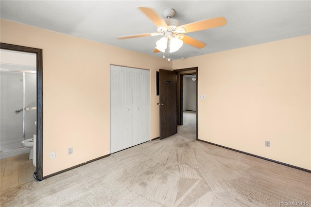 unfurnished bedroom featuring a ceiling fan, baseboards, ensuite bathroom, and light carpet