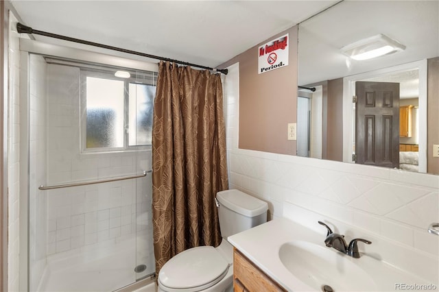 bathroom featuring vanity, tile walls, toilet, and a stall shower