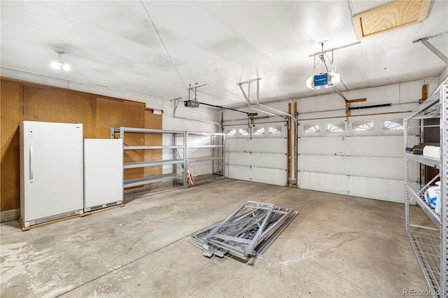 garage with a garage door opener and freestanding refrigerator